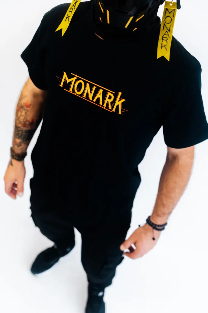 L'Empereur est debout, vêtu de vêtements en édition limitée Monark, démontrant ce qu'est la mode urbaine exclusive