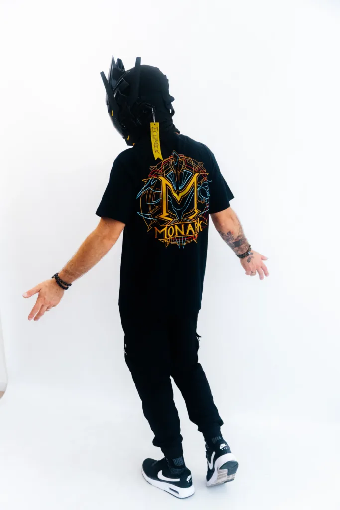 L'Empereur de dos écrate les bras en signe de victoire de la philosophie de Monark sur les autres mentalités