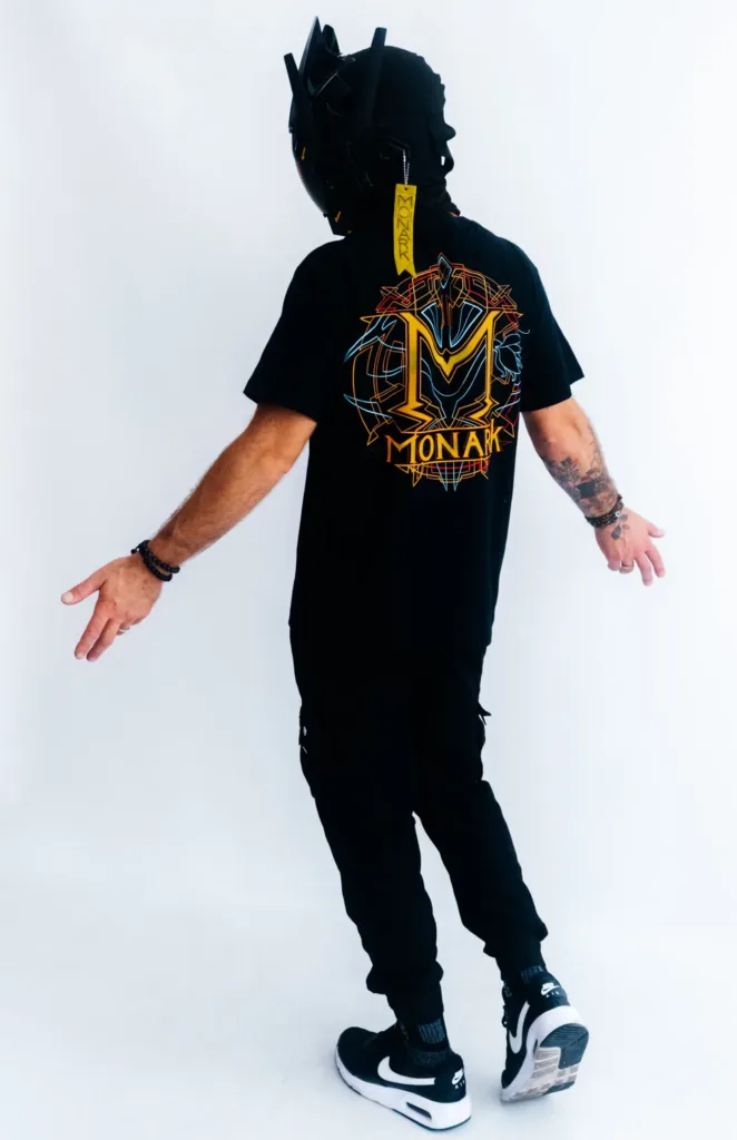 L'Empereur écarte les bras afin de présenter ses précommandes de vêtements Monark